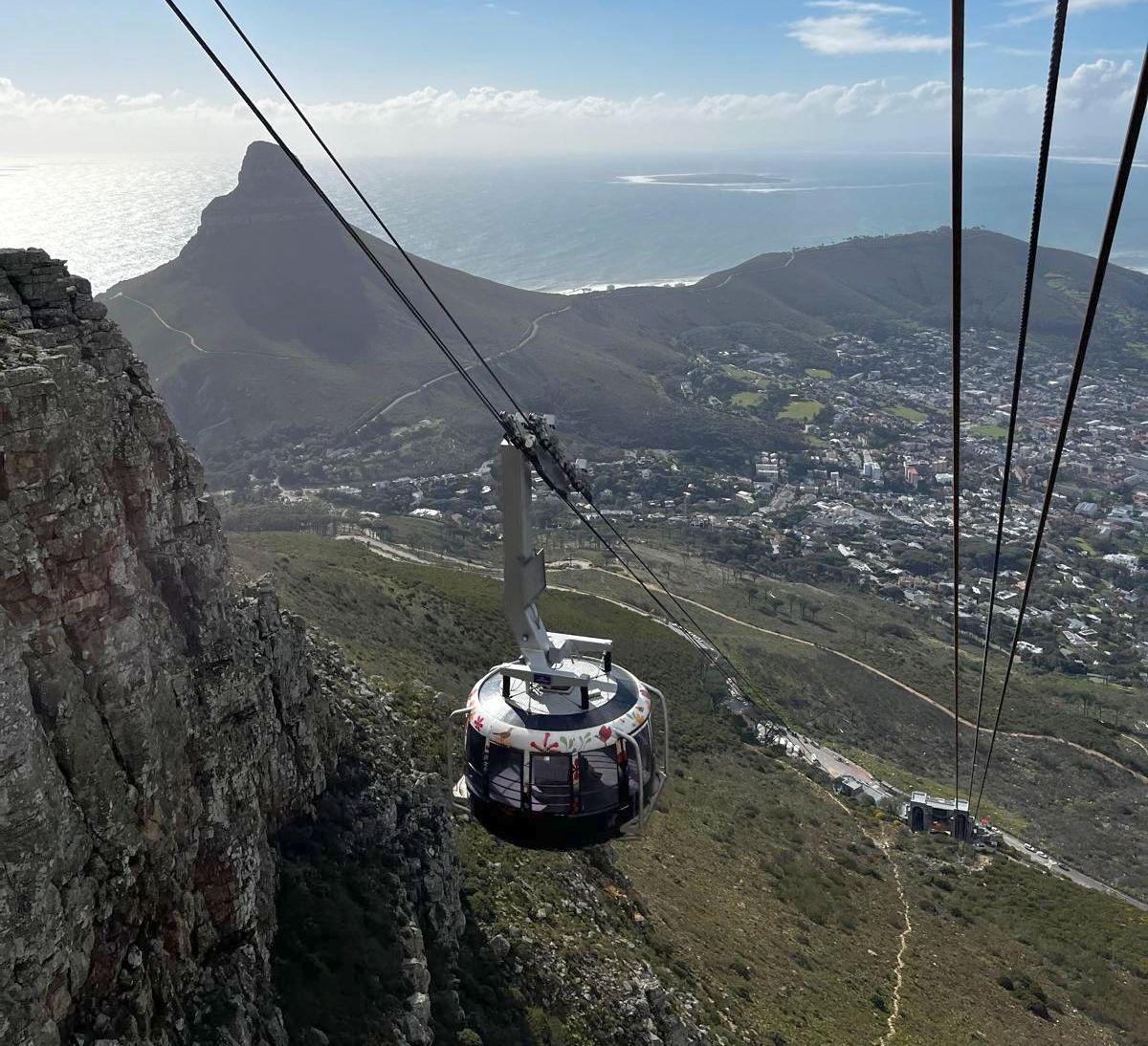 Blick vom Tafelberg auf Gondel und Tal. Zugseilprüfung am Tafelberg mit Blick auf die runde Gondel der Seilbahn bei Tag.