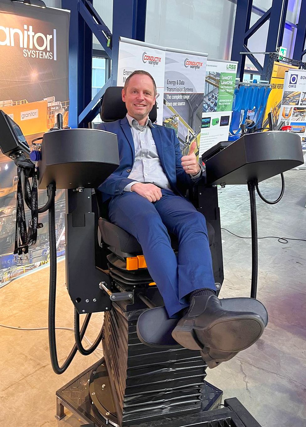 Martin sitzt lächelnd im ausgestellten Kranführerstuhl von BANG