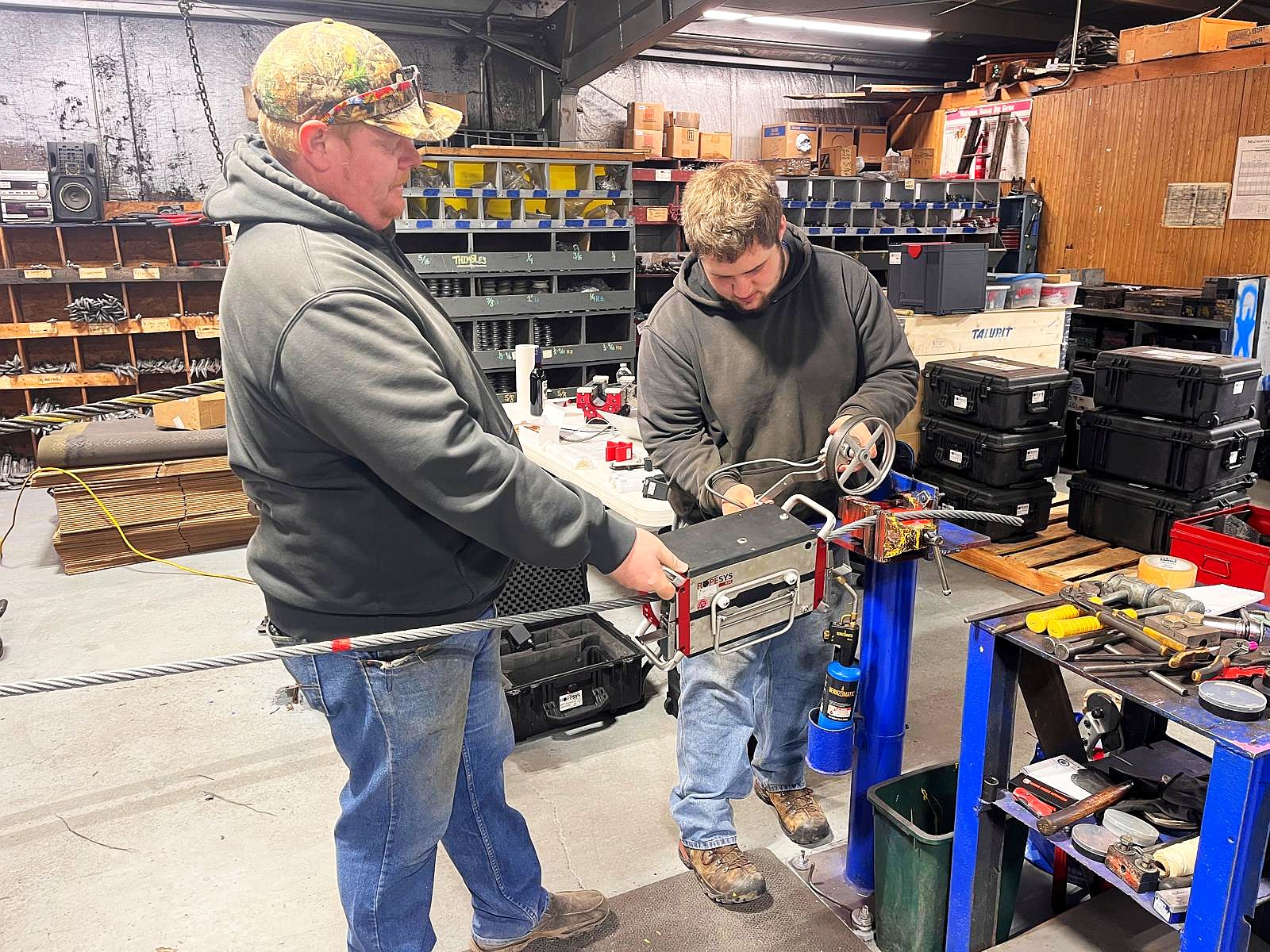 Techniker prüfen ein Seil mit ROPESYS Seilprüfgerät in einer Werkstatt