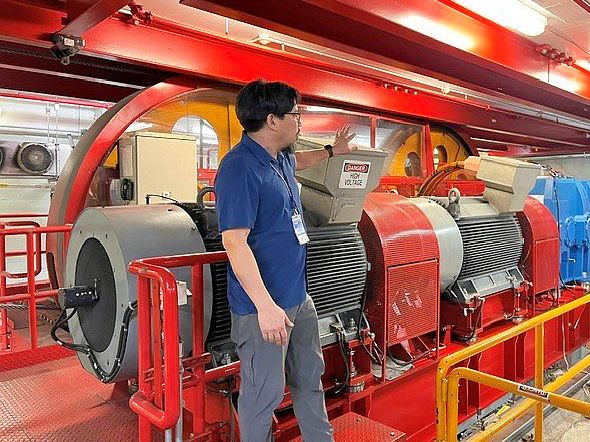 Techniker begutachtet den elektrischen Antrieb und die Motoren einer Seilbahnanlage im Maschinenraum.