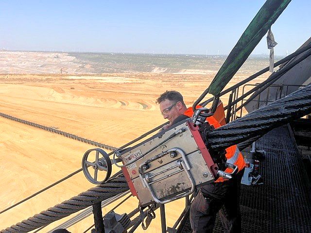 A Ropesys rope testing device mounted on a thick steel cable in an open-pit mine.
