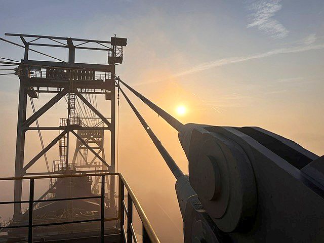 Silhouette of an industrial cable testing facility at an open-pit mine at sunset.